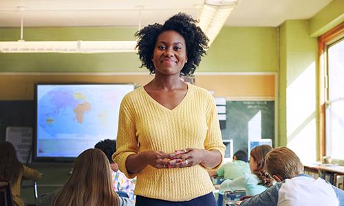 Portrait of a young teacher with her learners in the background